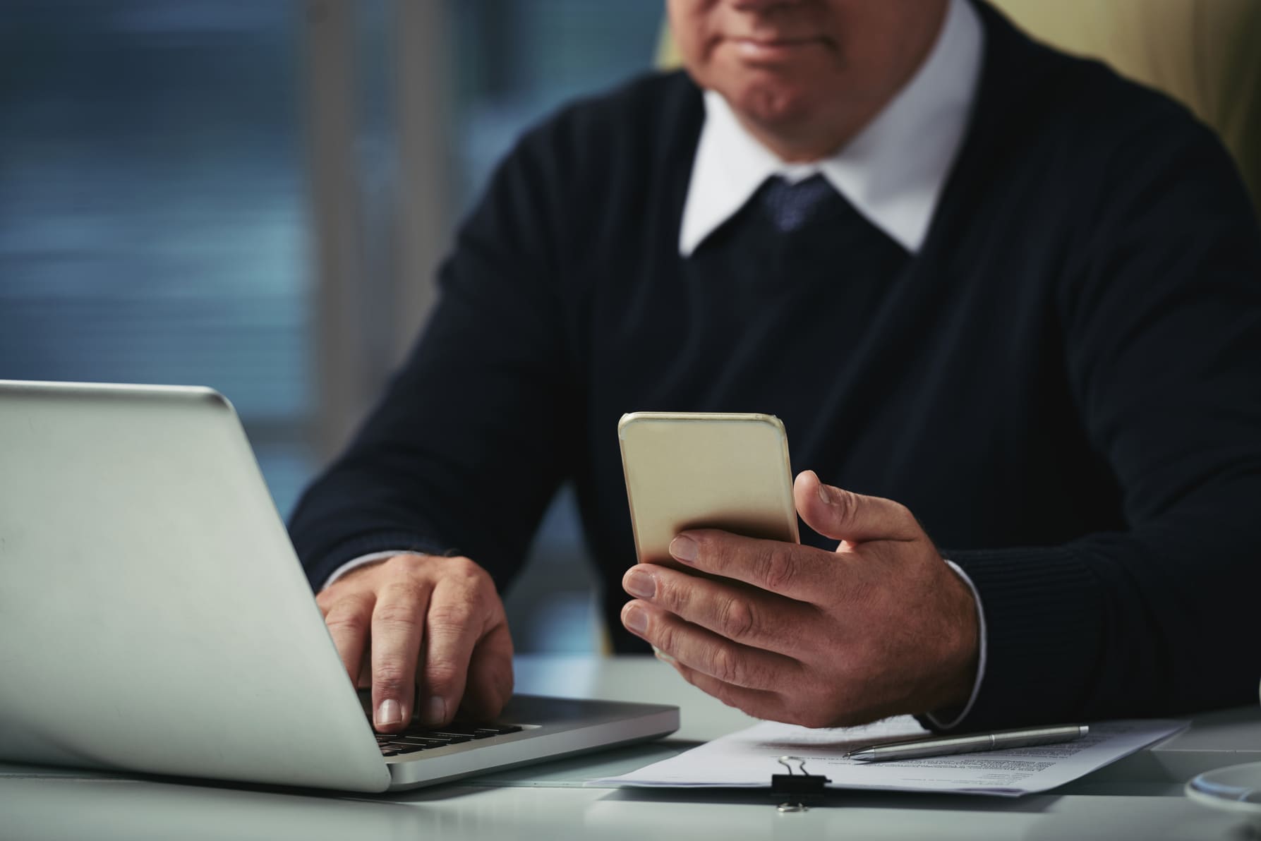 cropped-man-checking-messages-his-phone-office