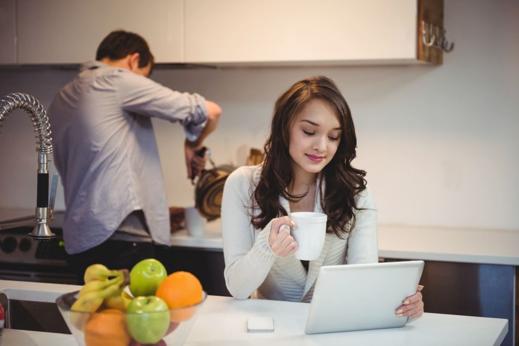 woman-using-digital-tablet-while-man-working-background